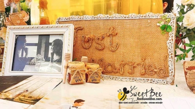 Quà tặng mật ong cho khách mời đám cưới trên bàn Gallery- <a target='_blank' href='/qua-tang-mat-ong-hu-vuong-55ml-trang-tri-giay-kraft-boc-nap-lo-que-go-lay-mat-q8.html'>Xem sản phẩm</a>